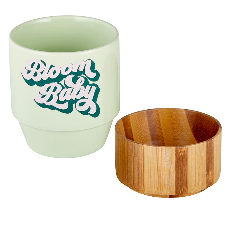 "Bloom Baby" ceramic mug shown next to the bamboo base.