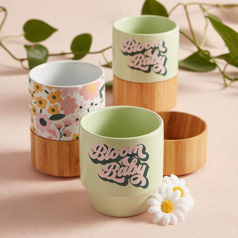 Two "Bloom Baby" ceramic mugs with the bamboo base and a floral ceramic mug with bamboo base.