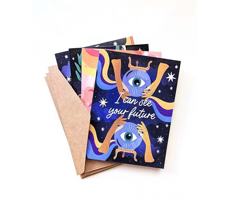 A set of celestial greeting cards with their envelopes. The top greeting card reads "I can see your future".