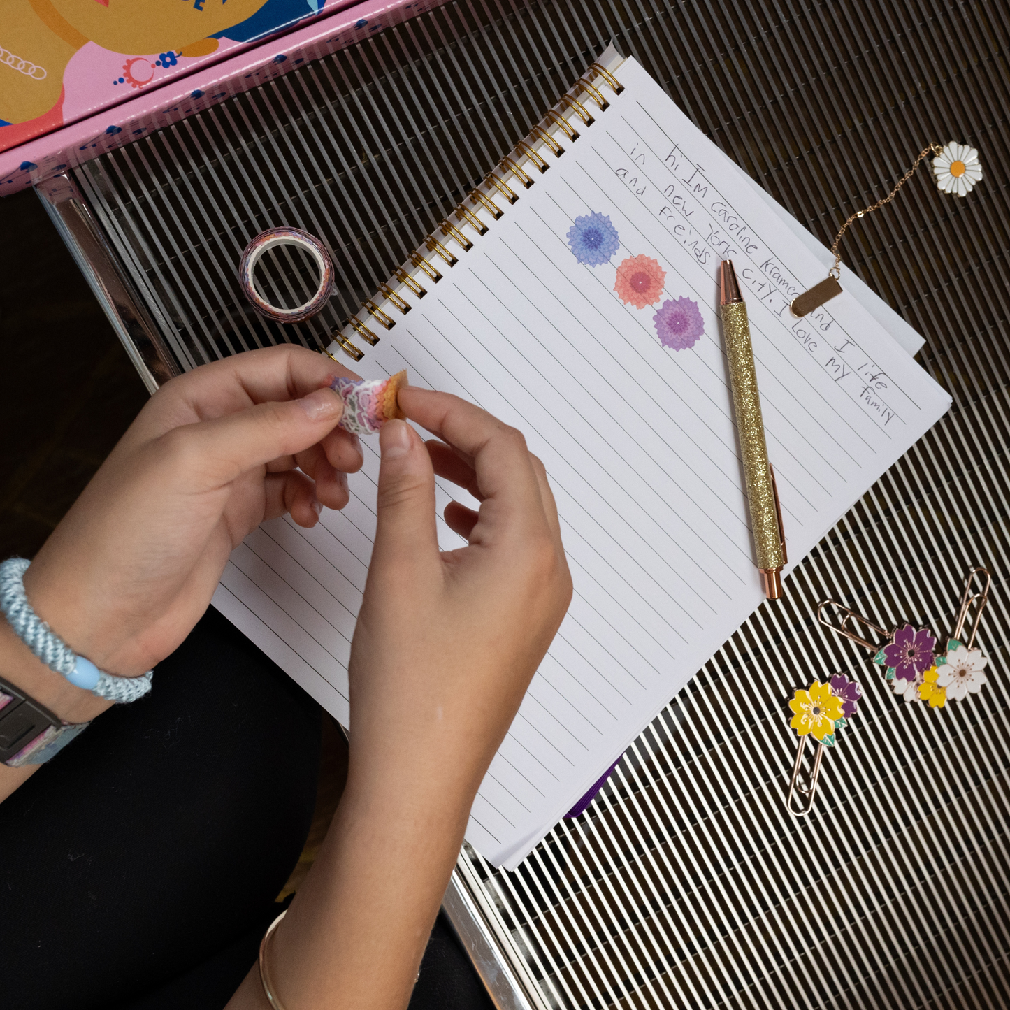 The journal opened with washi tape on the page, pen, paper clips with enamel flowers, and a clip bookmark. 