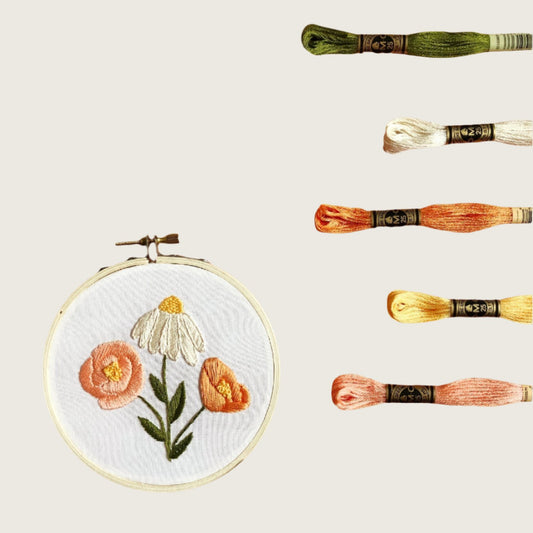 Image shows threads in various colors that will be used to embroider the three flowers that comes as a pattern in this Flower Embroidery DIY Kit.