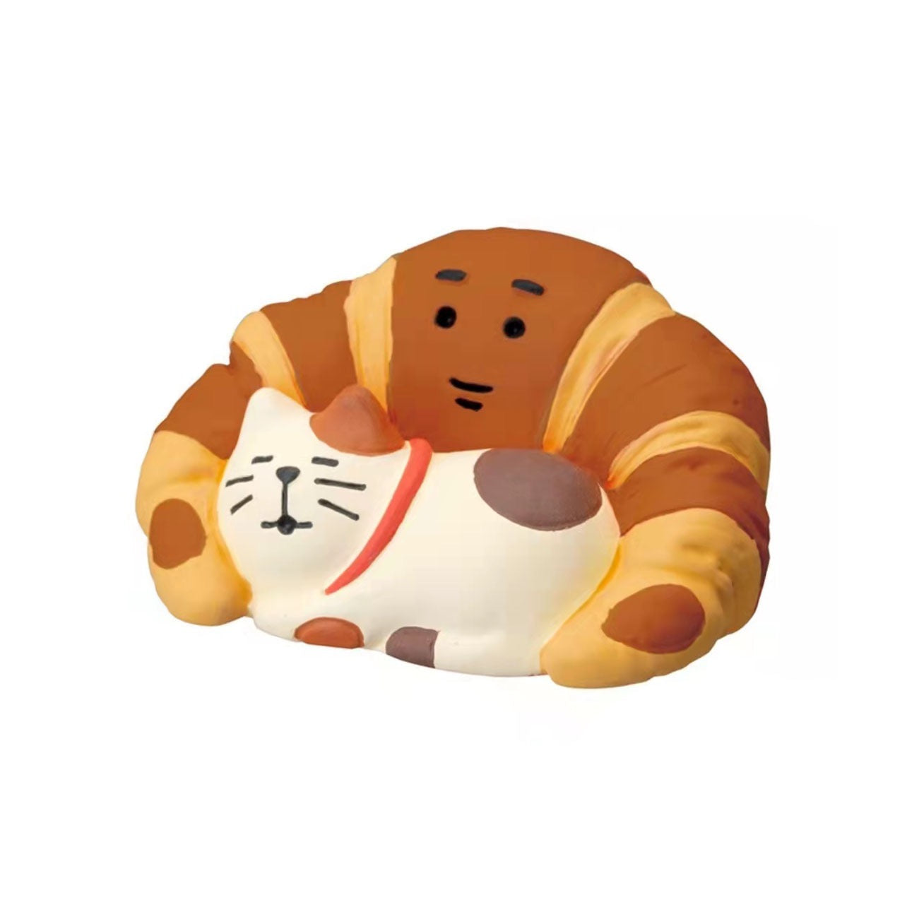 A Pawsome figurine #215 of a cat snuggled by a croissant with a smiley face.