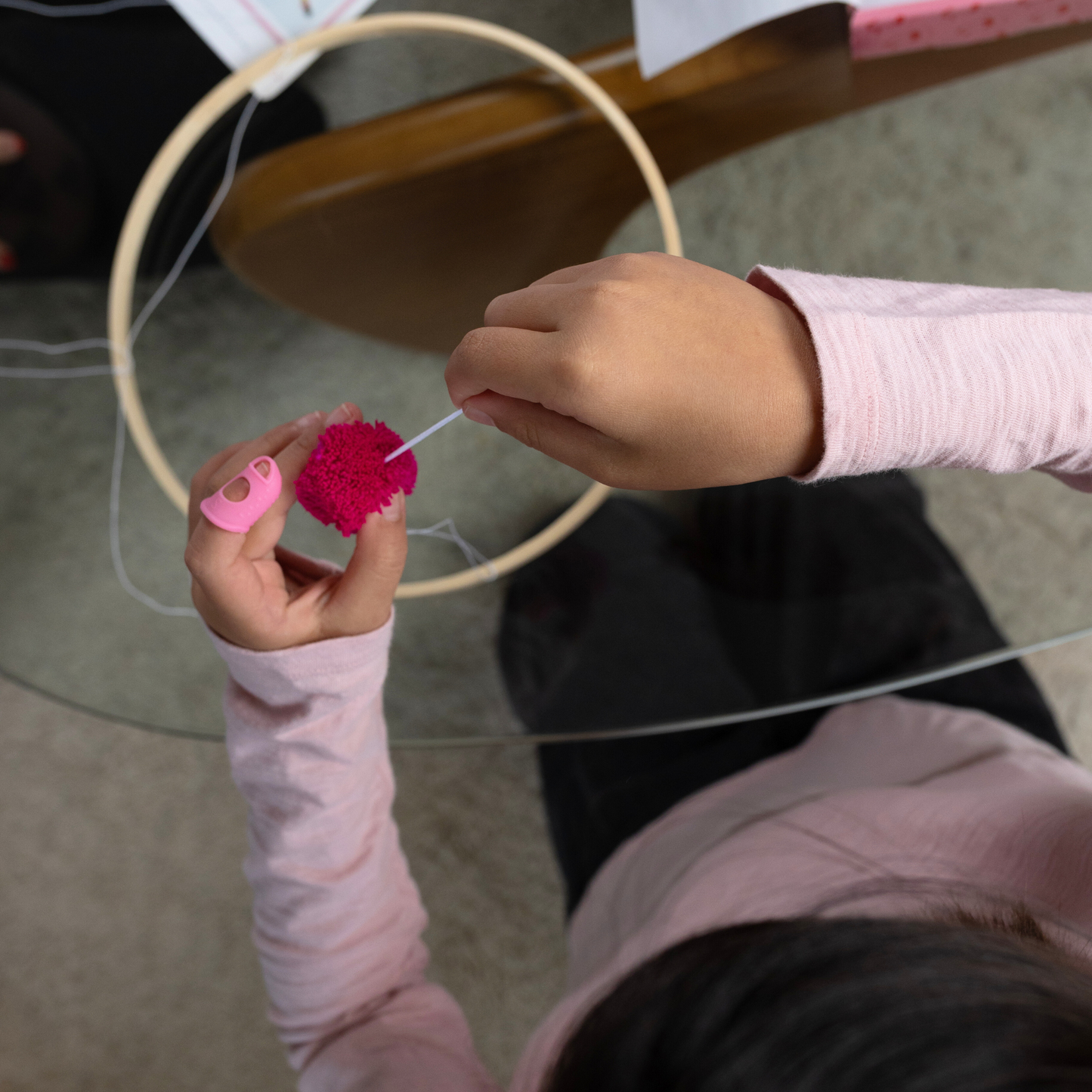 Child working on the "Discover like Maria" Pom Pom Mobile Craft.