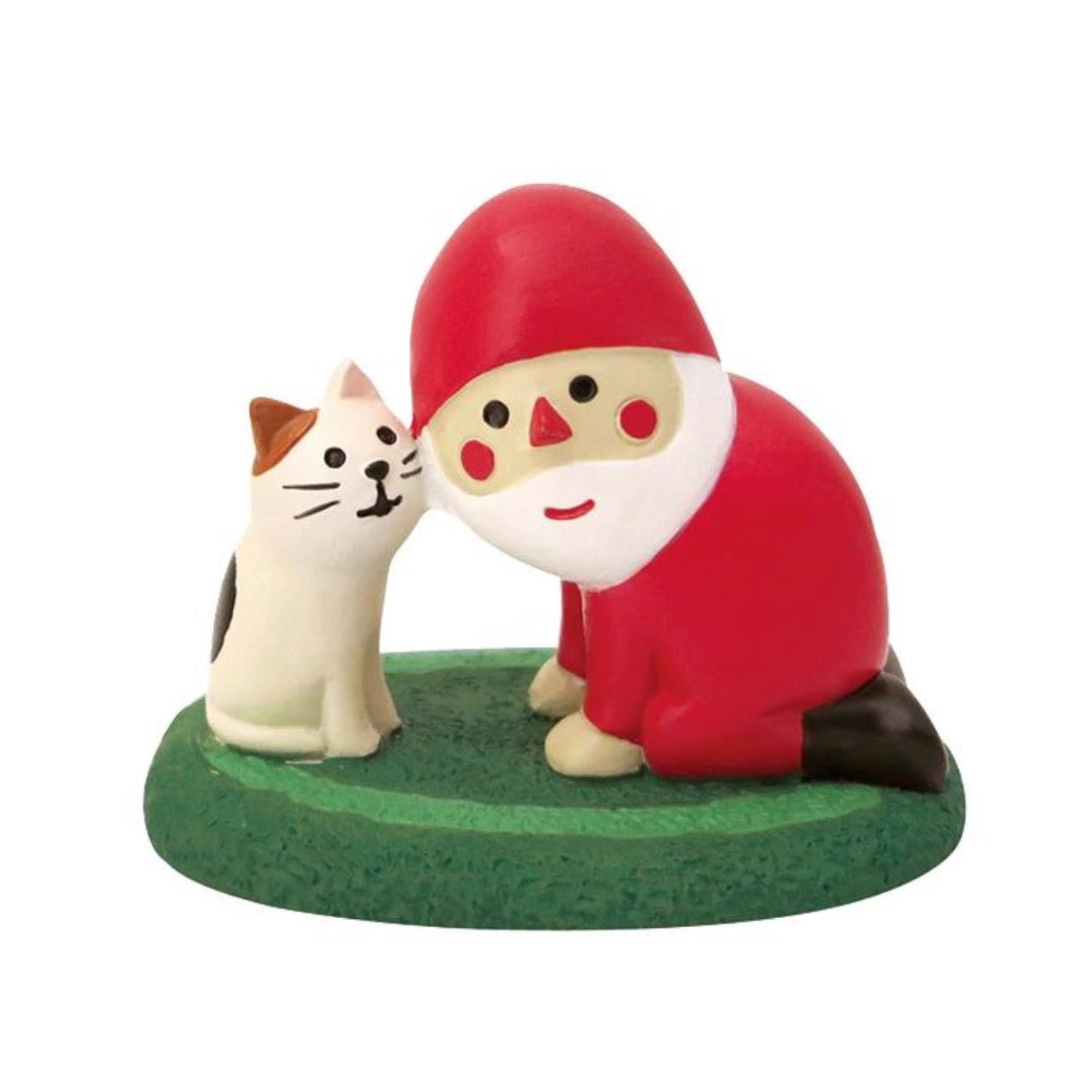 A Pawsome figurine ready for the Holiday season featuring Santa on his knees next to a cat on a green rug.