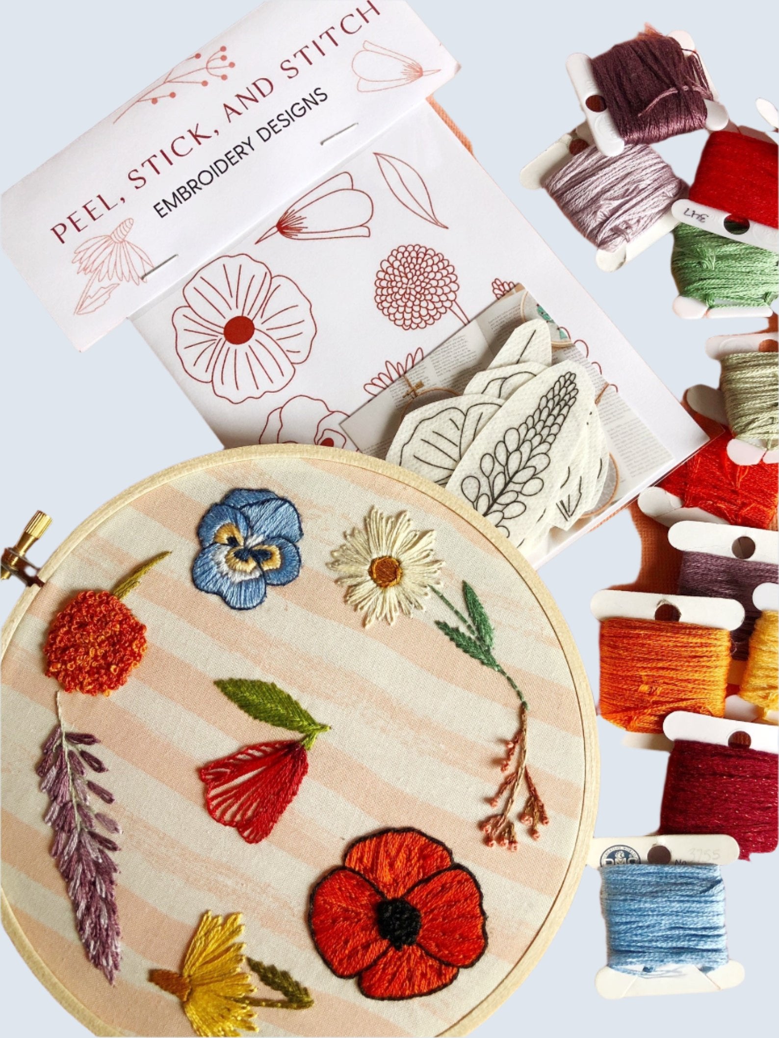 The Peel, Stick, Stitch Embroidery Designs kit shows the finished product, the threads with the different colors, and the bag with the patterns.